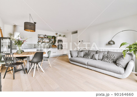 A living room combined with a dining area on the wooden floor of a modern cozy house A living room combined with a dining area on the wooden floor of a modern cozy house 90164660