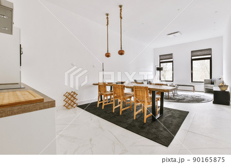 The interior of a spacious apartment with an open design and a view of the dining area with wooden furniture and a cozy living room 90165875