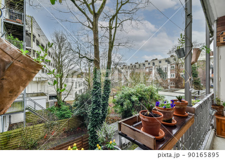 The balcony of the modern apartment is fully furnished with home plants and flowers The balcony of the modern apartment is fully furnished with home plants and flowers 90165895
