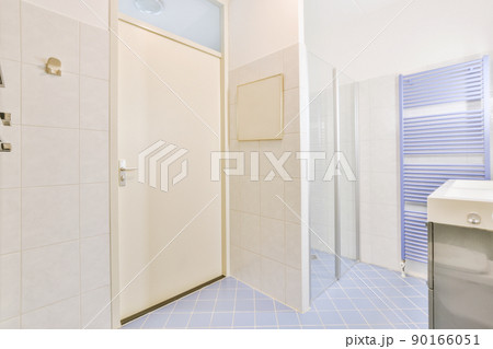 Bathroom interior with white and blue tiles and ceramic sink and glass shower cabin in a modern apartment Bathroom interior with white and blue tiles and ceramic sink and glass shower cabin in a modern apartment 90166051