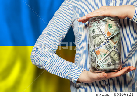 Blue and yellow color Ukrainian flag and US dollars money in human hand. Save Ukraine 90166321