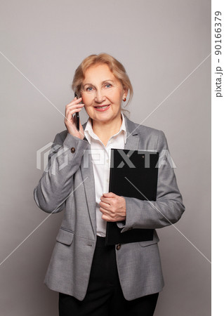 Successful confident friendly smart businesswoman uses her mobile phone 90166379
