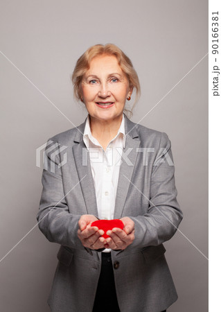 Attractive woman smiling and holding red heart in her hands 90166381