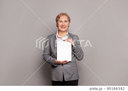 Happy middle aged senior lady holding digital tablet with empty display and smiling 90166382