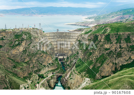 mountain landscape with an arched hydroelectric dam in the canyon and a reservoir in the valley mountain landscape with an arched hydroelectric dam in the canyon and a reservoir in the valley 90167608