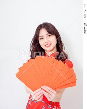 Portrait of Young asian woman wearing traditional cheongsam qipao dress with red envelopes in chinese new year on white background. 90167933