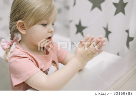 Little toddler girl in bathroom washing hands. Healthy, Child Hygiene concept. Little toddler girl in bathroom washing hands. Healthy, Child Hygiene concept. 90169388