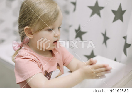 Little toddler girl in bathroom washing hands. Healthy, Child Hygiene concept. Little toddler girl in bathroom washing hands. Healthy, Child Hygiene concept. 90169389