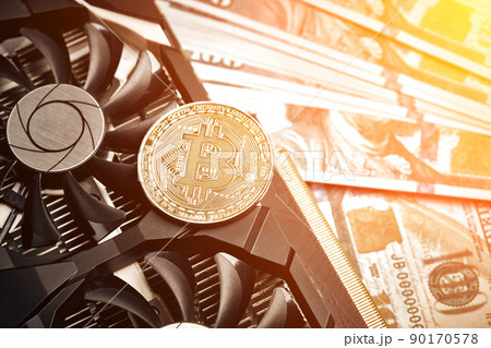 The coin of bitcoin lies on video card with dollars. Exchange bitcoin cash for a dollar. Sun flare 90170578