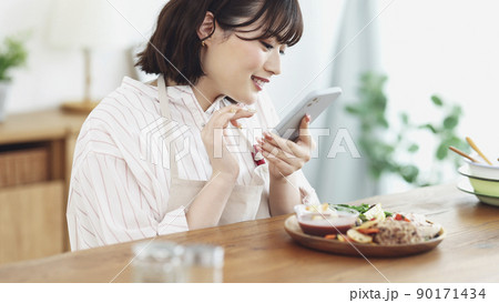 スマホで料理を撮影する若い女性 スマホで料理を撮影する若い女性 90171434