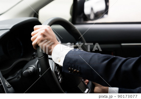 車を運転する男性の手元 90173077