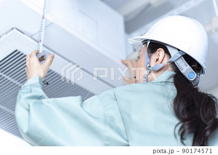 現場調査する女性の空調設備エンジニア 現場調査する女性の空調設備エンジニア 90174571