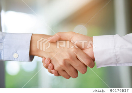 Closeup of a business hand shake between two colleagues Plaid shirt Closeup of a business hand shake between two colleagues Plaid shirt 90176637