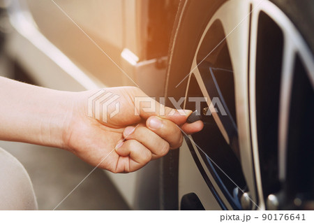 close up hand man car parking a check and inflate the tire fill up the air for safe driving on the go. Transportation travel vehicle concept. close up hand man car parking a check and inflate the tire fill up the air for safe driving on the go. Transportation travel vehicle concept. 90176641