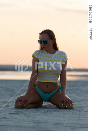Sexy woman in t shirt sitting on beach 90176999