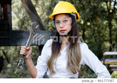Asian female engineering worker with industrial wrench in workshop. Engineer woman working in manufacturing business. Profession and Construction Worker Concept Asian female engineering worker with industrial wrench in workshop. Engineer woman working in manufacturing business. Profession and Construction Worker Concept 90177587