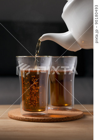 Pour hot tea into a glass clear Pour hot tea into a glass clear 90180493