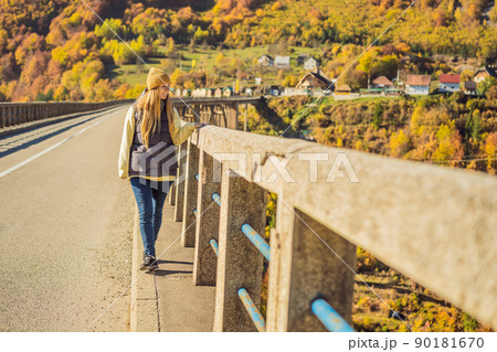 Montenegro. Woman touriste in background of Dzhurdzhevich Bridge Over The River Tara foggy morning. Travel around Montenegro concept. Sights of Montenegro 90181670