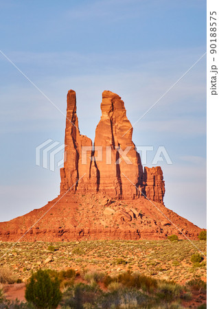 Vertical large red rock pillar in desert with blue sky 90188575