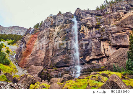 Large waterfall over vertical cliffs in mountains 90188640