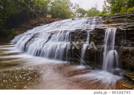 Large cascading waterfall over slates and cliffs of rock 90188745