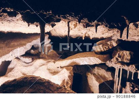 Dark lighting of cave formations with water dripping stalactites Dark lighting of cave formations with water dripping stalactites 90188846