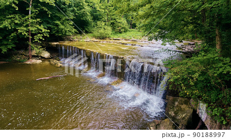 Long stretch of waterfalls over cliff in river buried in the forest 90188997