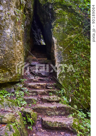 Stair stone steps up into rock tunnel 90189064