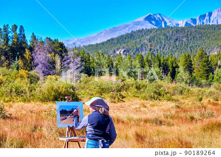 Female painter artist outside desert painting scene of mountain landscape Female painter artist outside desert painting scene of mountain landscape 90189264