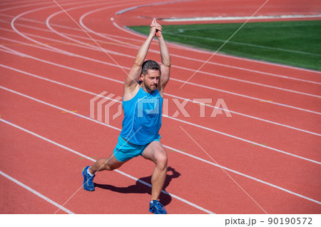 male jogger athlete training and doing workout outdoors, stretching 90190572
