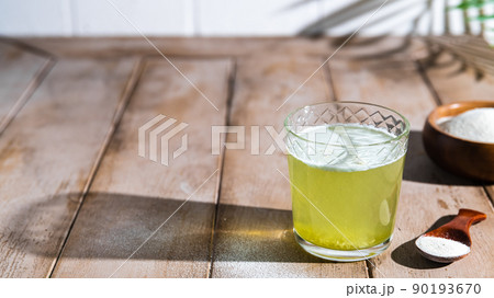 Collagen powder and glass of water on wooden background. Collagen powder and glass of water on wooden background. 90193670