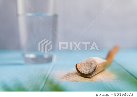Collagen powder in spoon on wooden blue background. 90193672