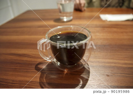テーブルの上に置かれた耐熱ガラスカップに入ったコーヒー テーブルの上に置かれた耐熱ガラスカップに入ったコーヒー 90195986