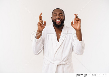Headshot of African American man crossing fingers wishing and praying for miracle, hoping for the best, isolated against white copy space wall. Positive human emotions, expressions and feelings. 90196038