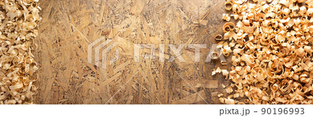 Wood shavings at table background. Wooden shaving on old plank board Wood shavings at table background. Wooden shaving on old plank board 90196993