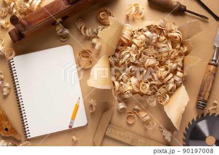 Woodworking carpenter chisel tool and wood shavings on paper background Woodworking carpenter chisel tool and wood shavings on paper background 90197008