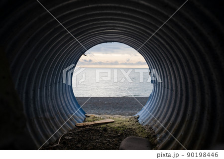 View from water drainage pipe on sea beach. 90198446