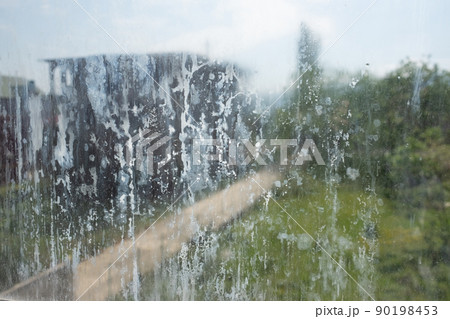 Dirty glass lit by the sun. Unclean window soiled with dus 90198453