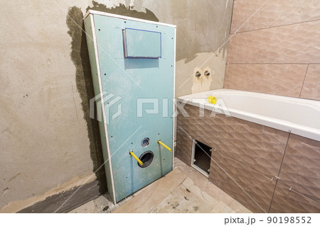 Unfinished reconstruction of bathroom or toilet with ceramic tiles installed on walls of drywall, place for lavatory and bath. Unfinished reconstruction of bathroom or toilet with ceramic tiles installed on walls of drywall, place for lavatory and bath. 90198552