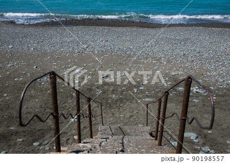 Staircase to beach. Blue water and stones on beach Staircase to beach. Blue water and stones on beach 90198557