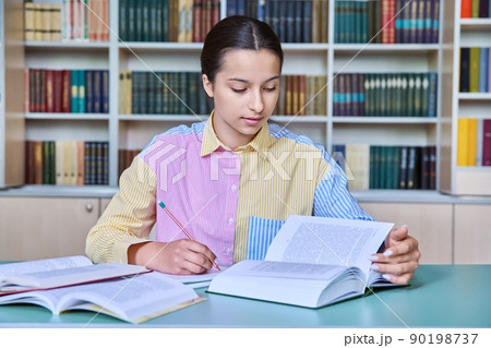 Teenage girl student studying in the school library 90198737