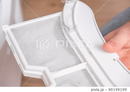 A man takes a lint filter out of dryer and cleans 90199199