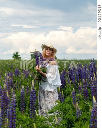 Woman walking through a blooming meadow Woman walking through a blooming meadow 90199313