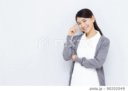 笑顔で悩んでいる30代の女性看護師 笑顔で悩んでいる30代の女性看護師 90202049