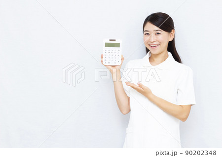 電卓を持つ30代美容クリニックのスタッフ 90202348