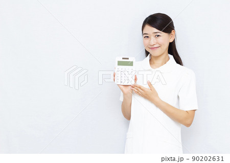 電卓を持つ30代美容クリニックのスタッフ 90202631