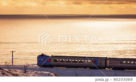 夕焼けの海岸を行く特急列車 90203069