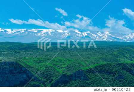 beautiful wooded mountain landscape with snow covered peaks in the background beautiful wooded mountain landscape with snow covered peaks in the background 90210422