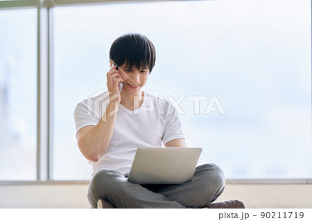 ノートパソコンをタイピングする若い男性 90211719