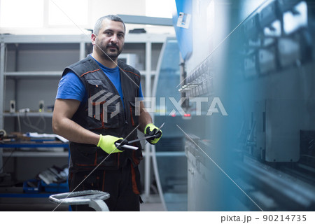 A smart factory worker or engineer makes machines in a production workshop. The concept of industry and engineering. Selective focus A smart factory worker or engineer makes machines in a production workshop. The concept of industry and engineering. Selective focus 90214735
